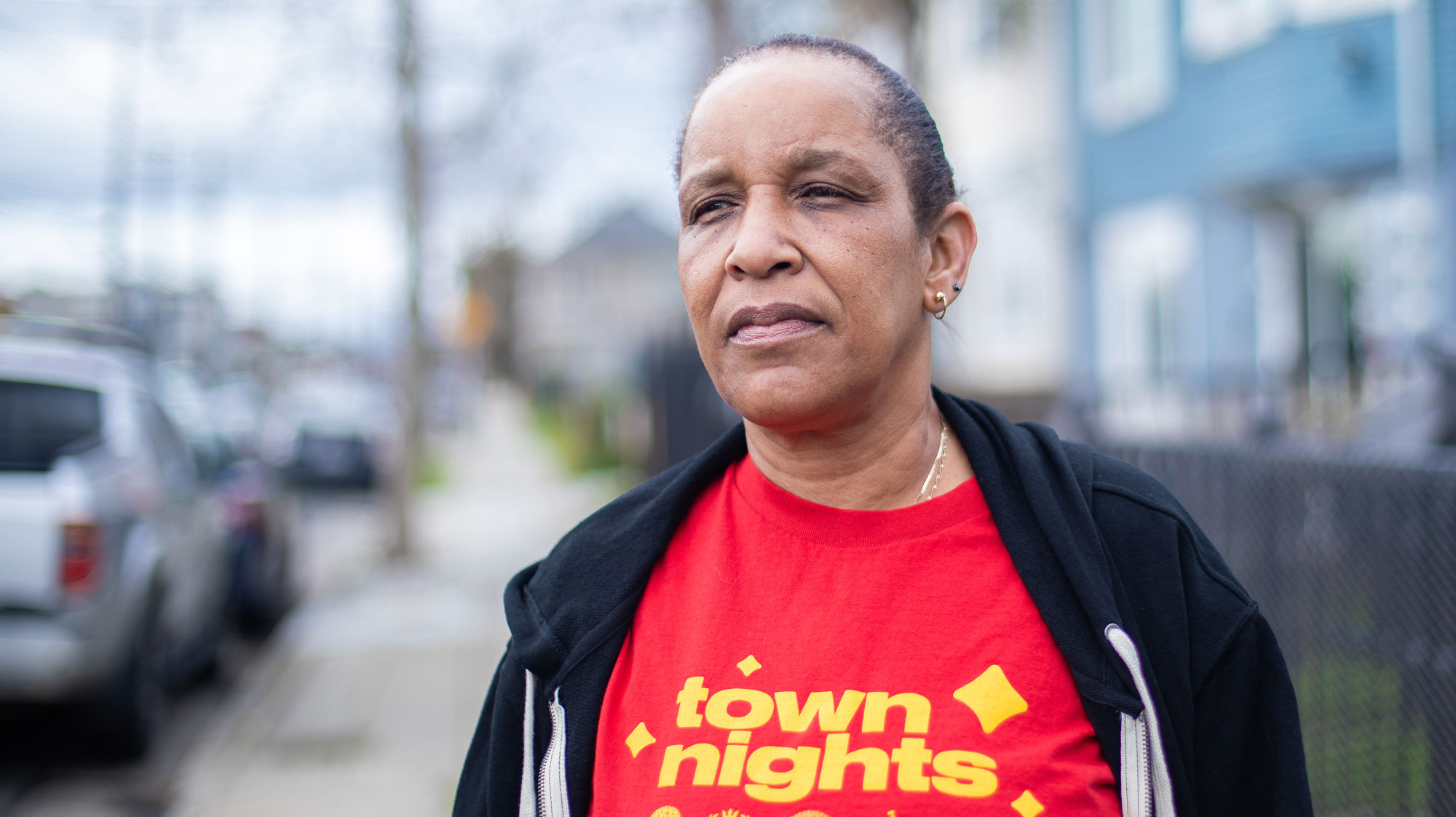 Annette Miller stands on a sidewalk in front of her West Oakland home