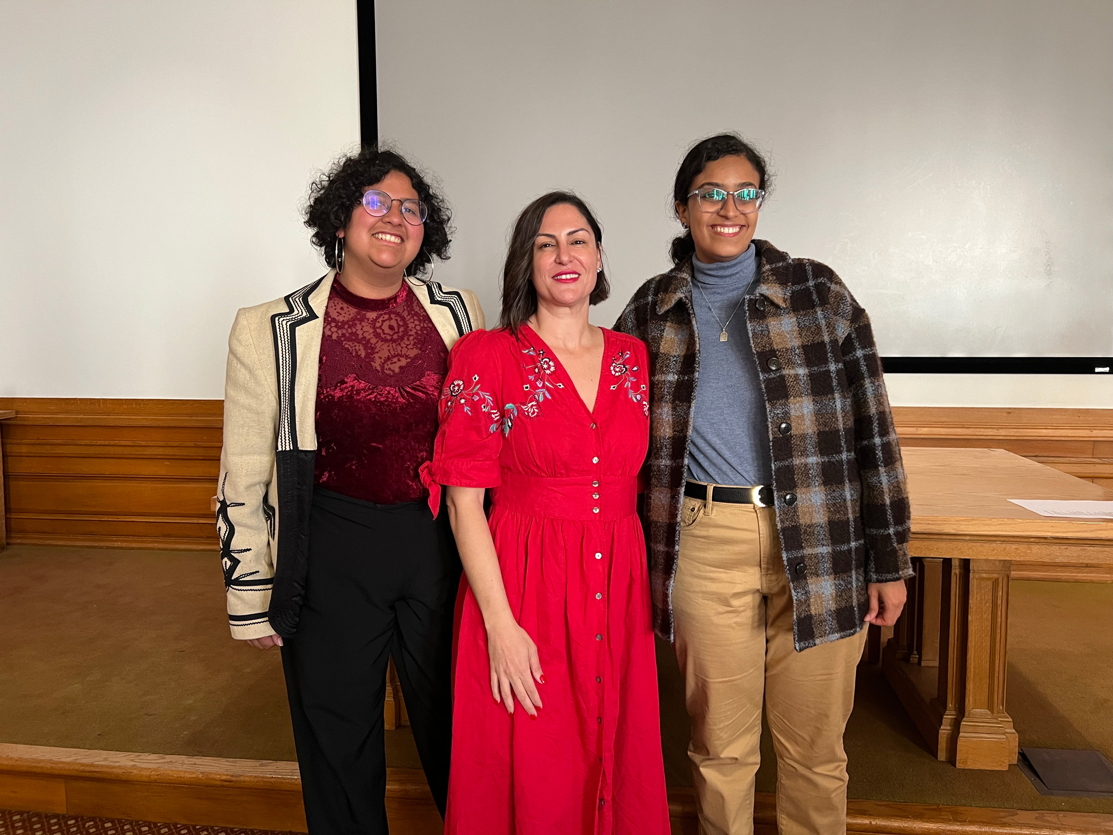 Three poets standing together in a UC Berkeley lecture hall
