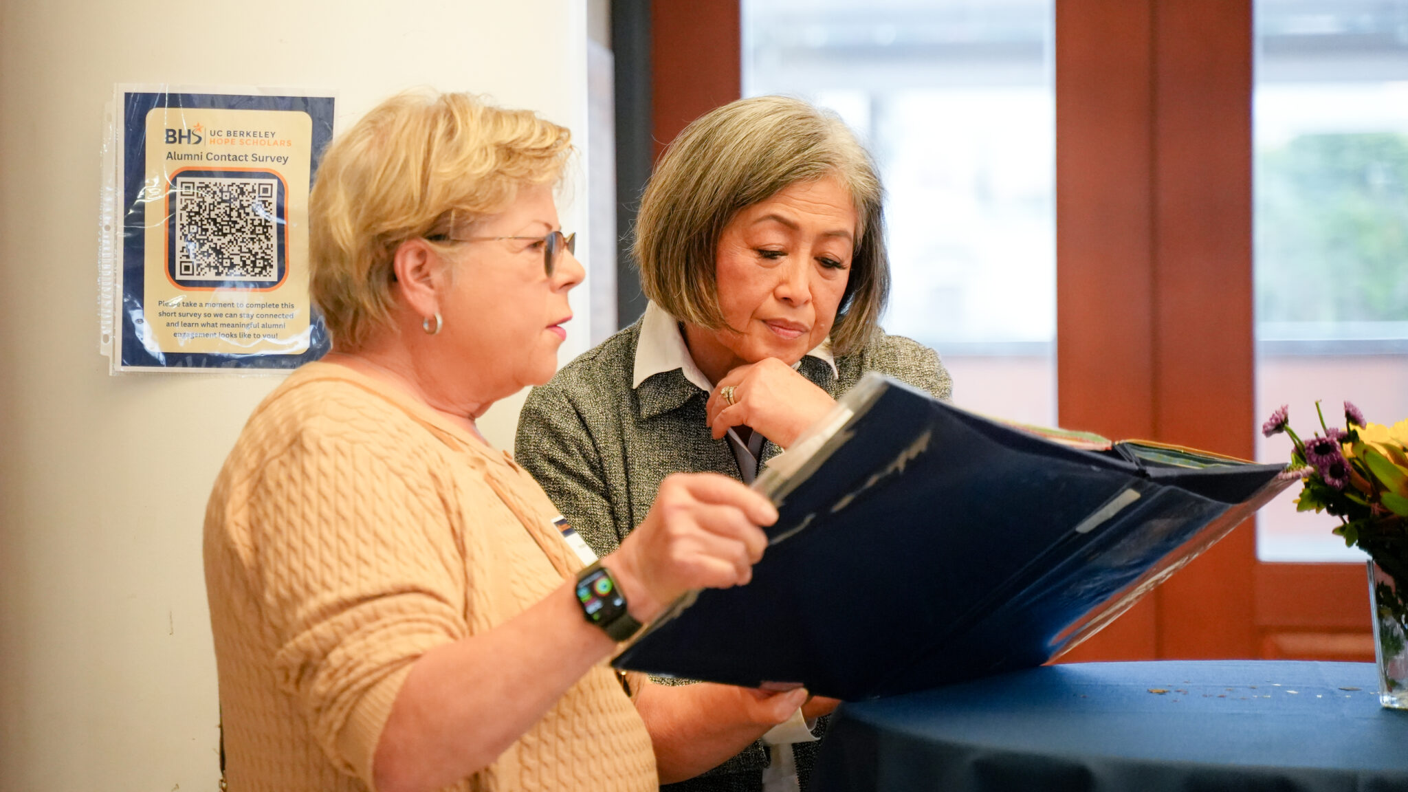 two women look at a photo album