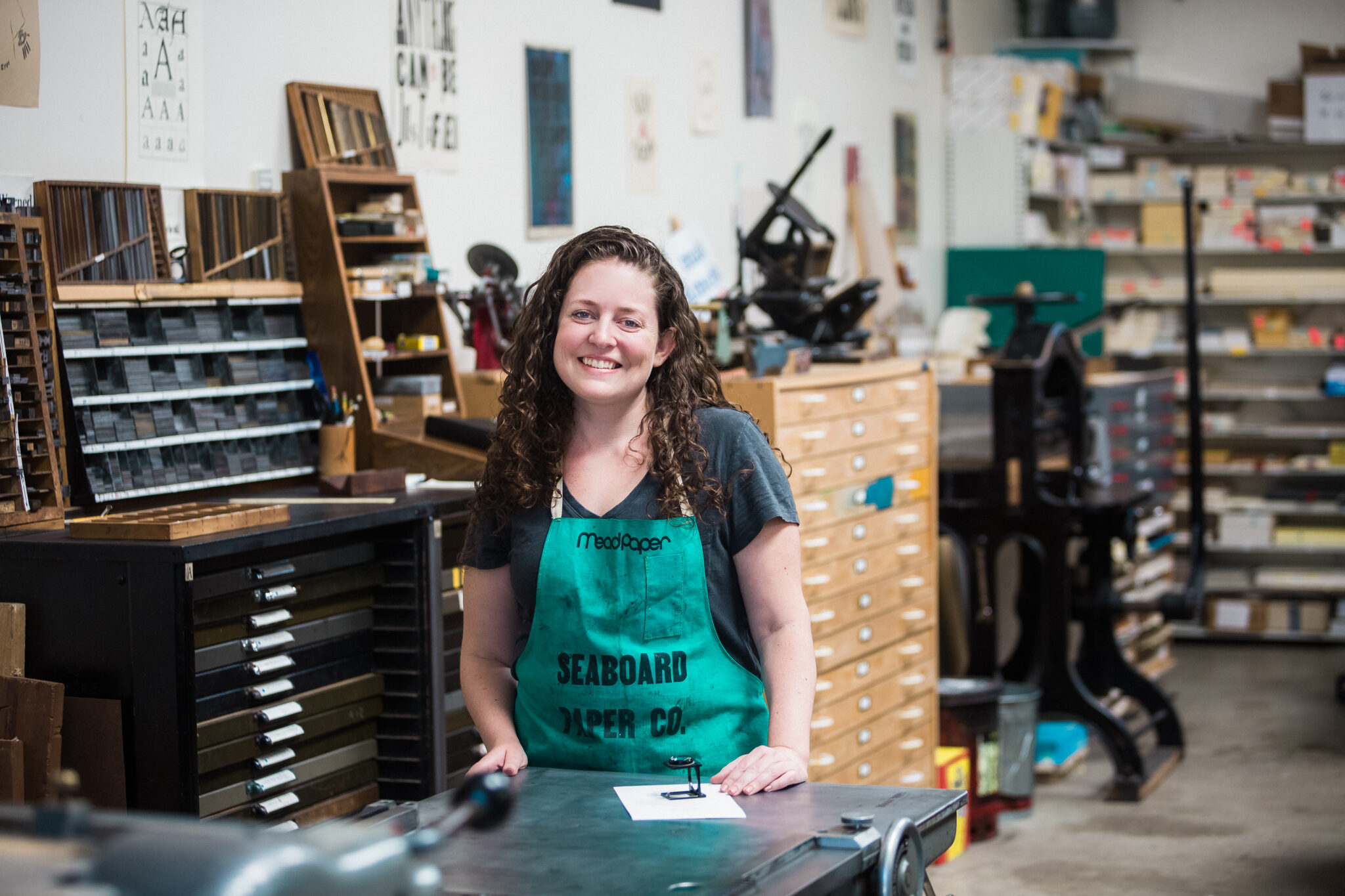 A woman in a green smock in a workshop