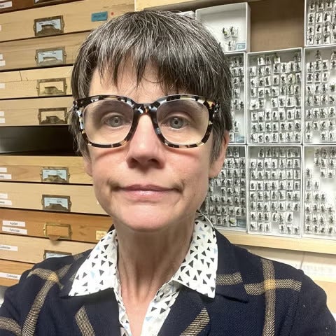 A woman with glasses in front of insect exhibits