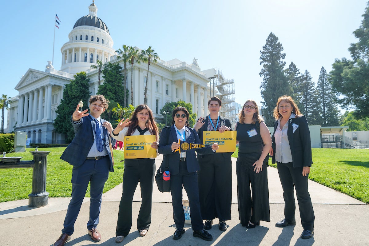 A group of people standing in front of the State Capitol Building in Sacramento