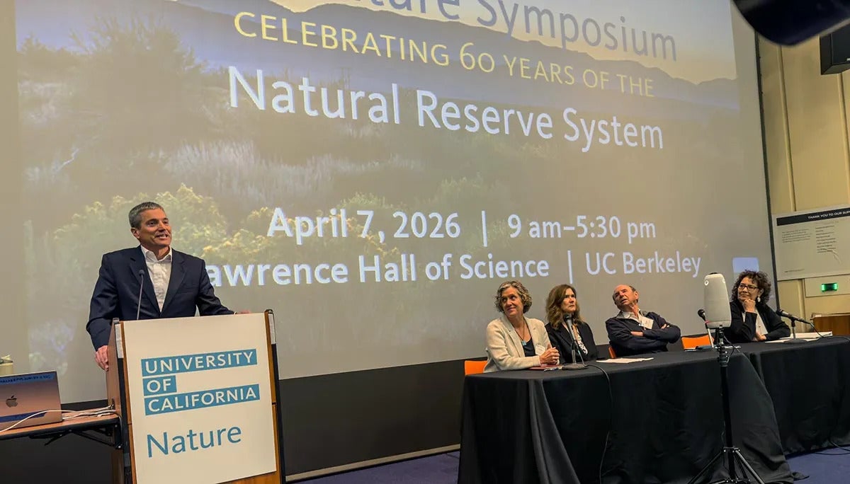 Secretary Crowfoot at the podium with four people at a table