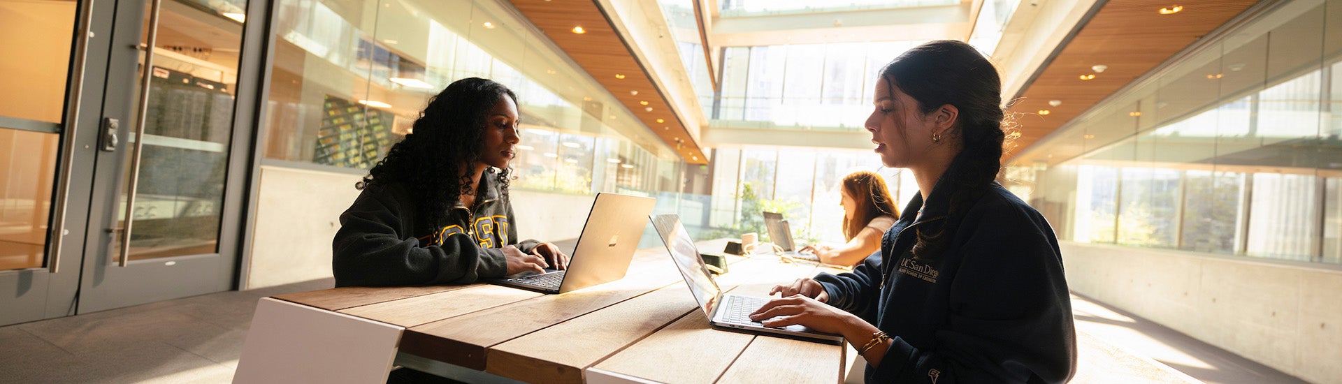 Three students working together in a bright common area