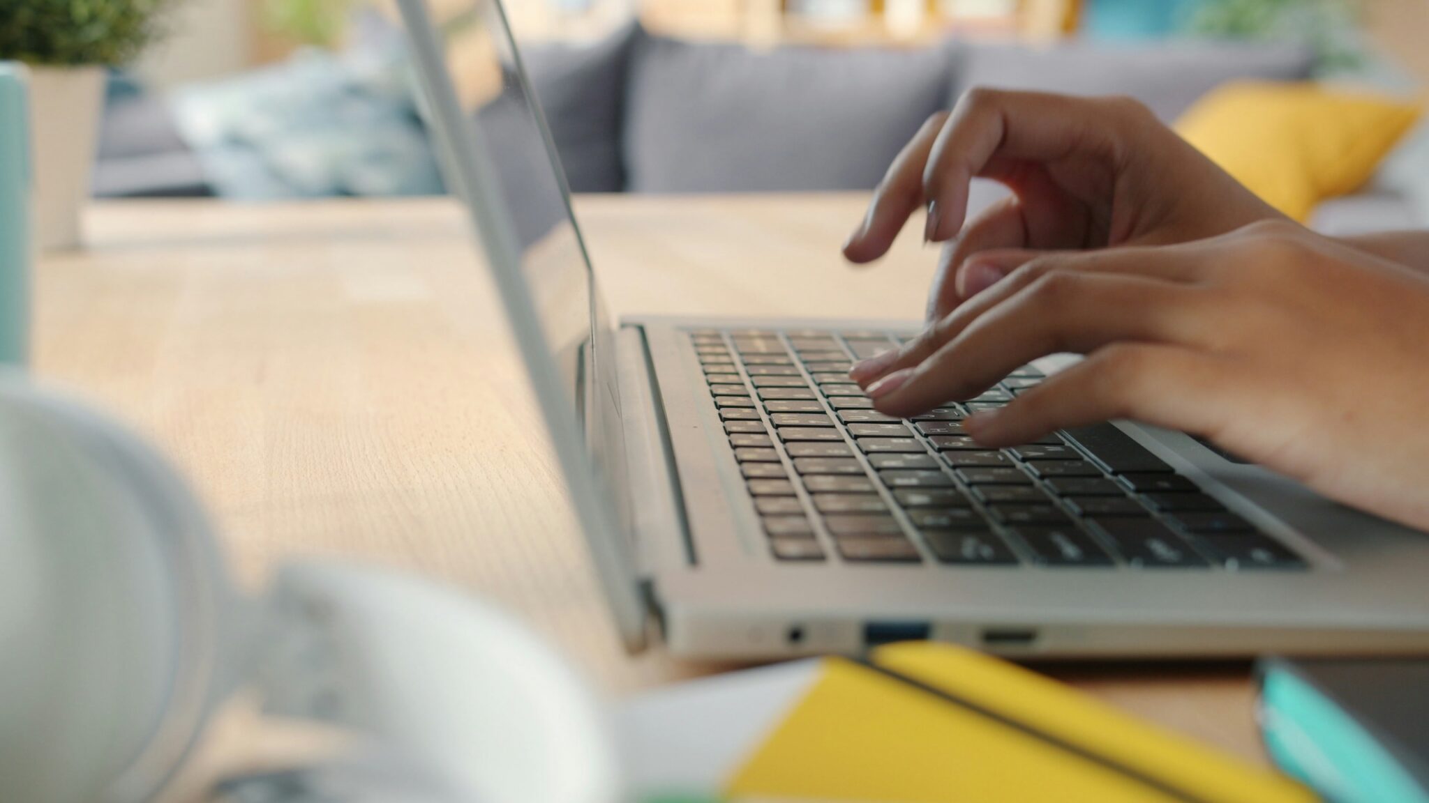 Hands type on a laptop keyboard