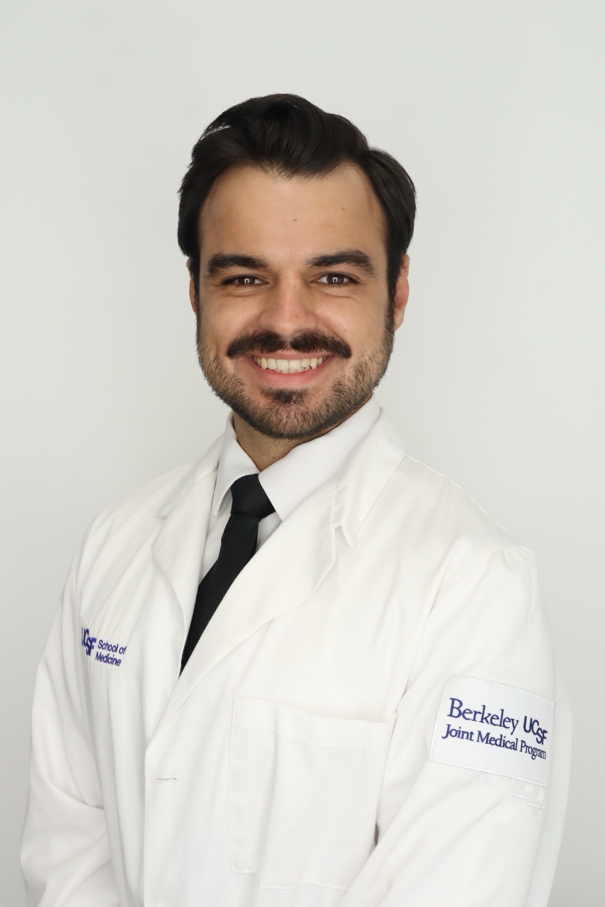 Young man with a beard in a white lab coat Jordan Roiland