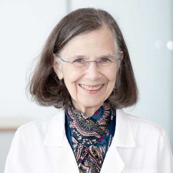 A woman with glasses and a white doctor's coat
