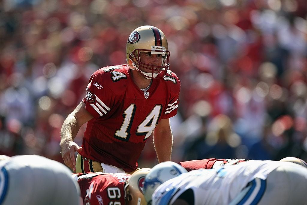 A San Francisco 49ers quarterback stands at the line of scrimmage before snapping the ball
