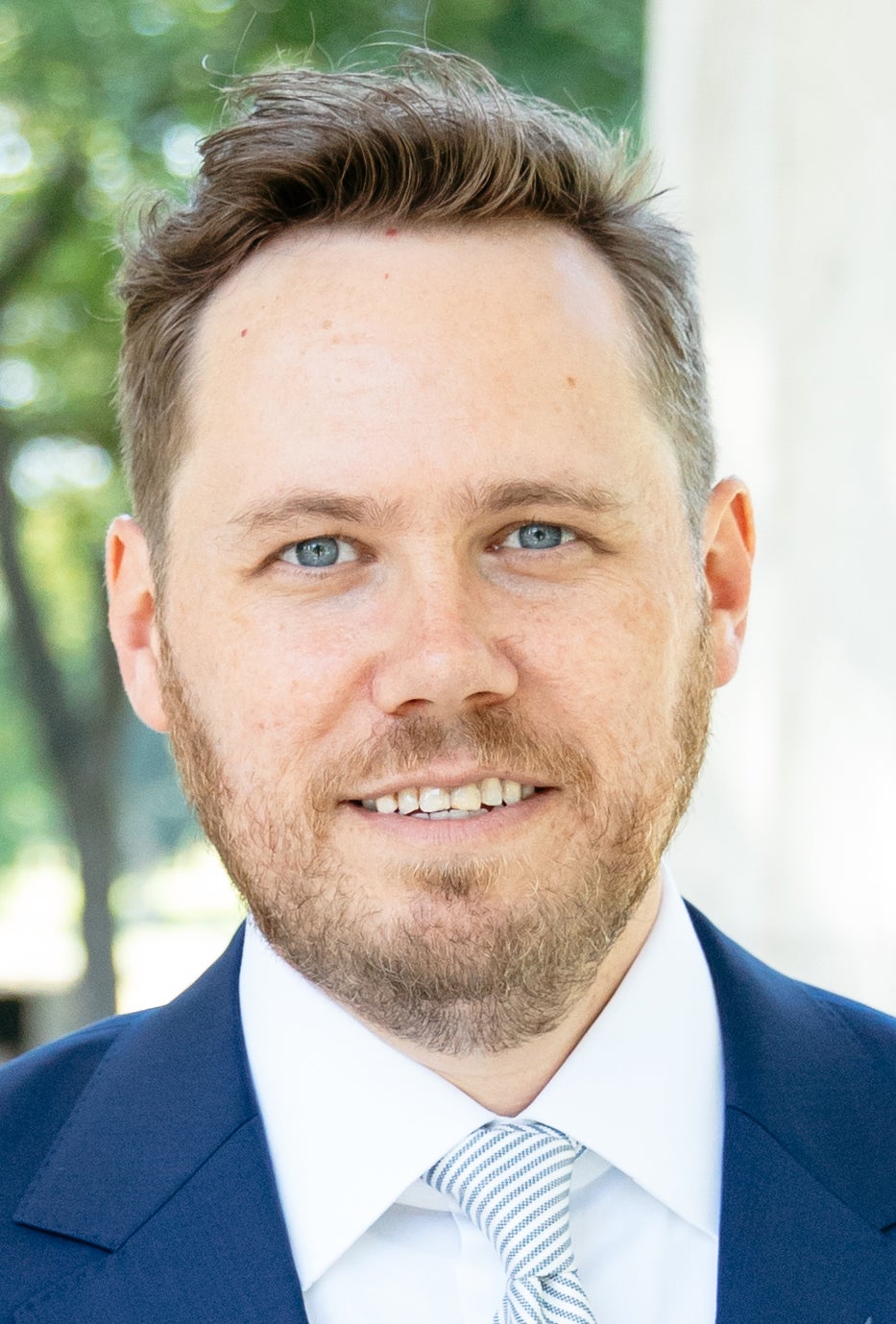 Man in blue blazer with beard smiles