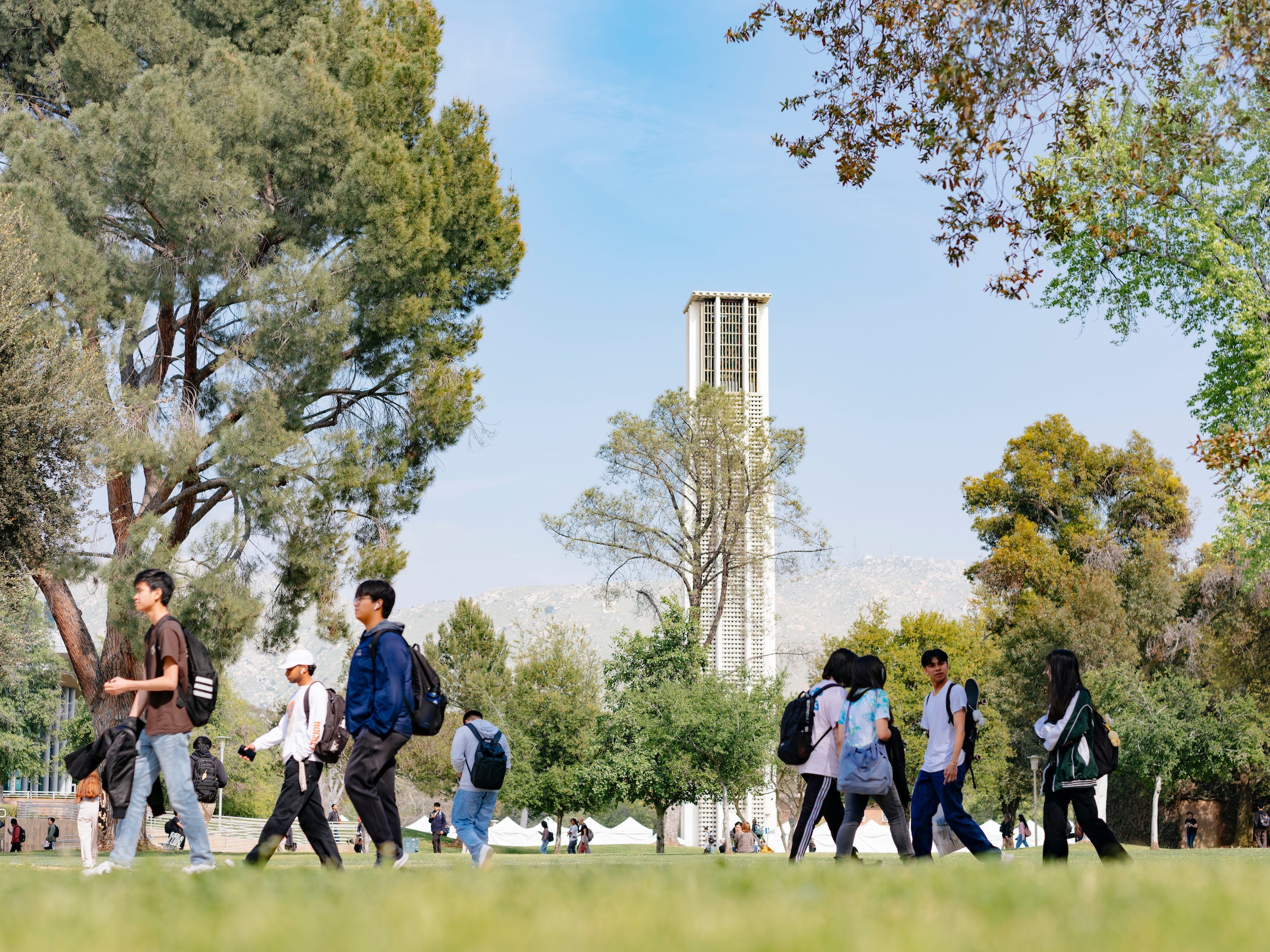 Students walk by the Bell Tower on the UC Riverside campus
