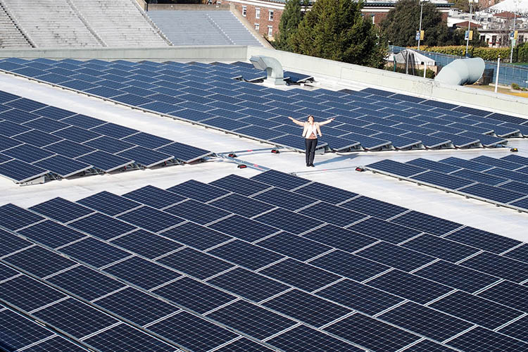 Kira Stoll, UC Berkeley's director of sustainability stands with solar panels on the top of the Recreational Sports Facility. 