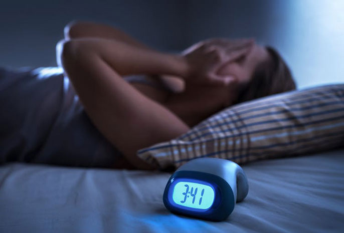 Clock shows early morning next to a bed