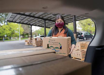 Annie Adachi loads food into the back of a car