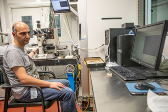 Ahmed Elnewishy stares at a computer while controlling a microscope