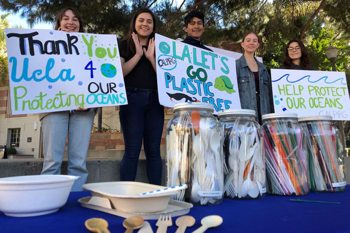 Students hold up posters thanking UCLA for going single-use plastic-free