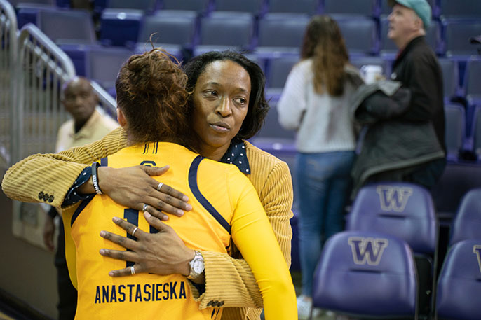 Charmin Smith consoles one of her players with a hug after a basketball game