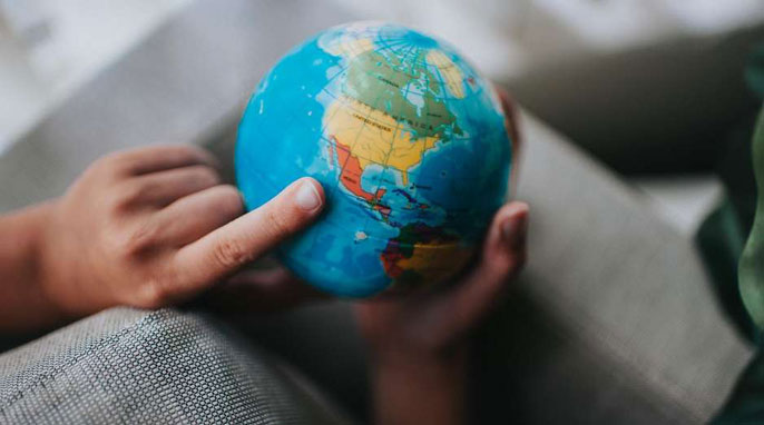 Finger pointing at globe