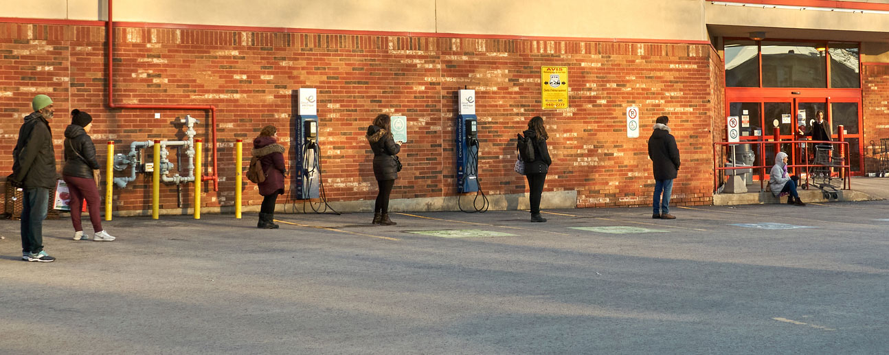 people standing six feet apart outside a grocery store