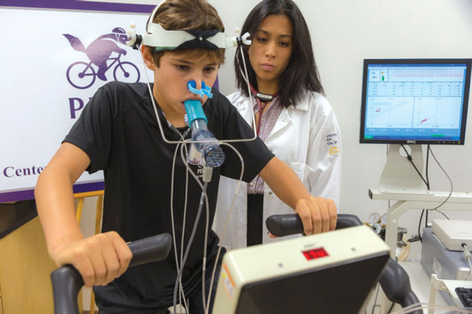 Kid exercises next to female researcher