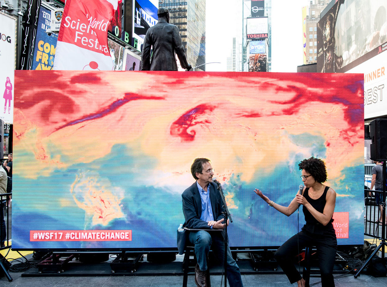 Ayana Elizabeth Johnson in front of a colorful backdrop with Andy Revkin in Times Square