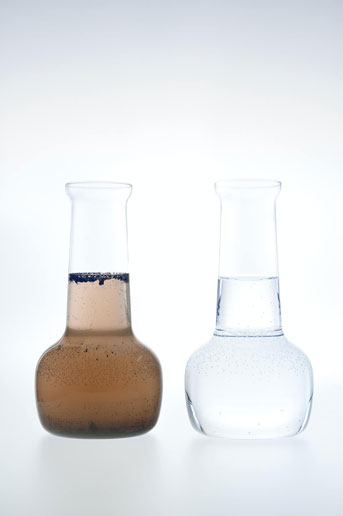 Two glass vials, one containing brown dirty water and the other clean clear water