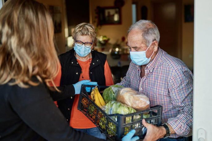 Two older people receive a food delivery