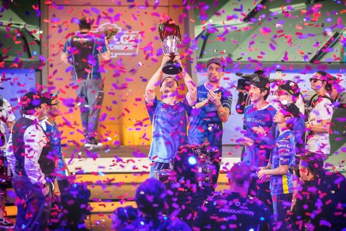 gamers lift a trophy under confetti