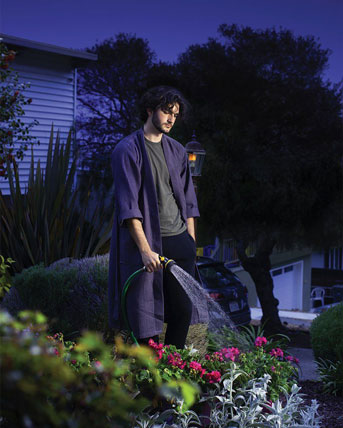 Man watering plants at night