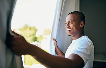 Man opens window smiling