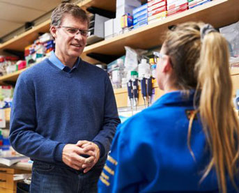 Matthias Hebrok speaking to a woman in a lab coat