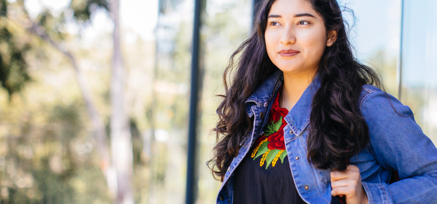 A Latinx woman standing on campus