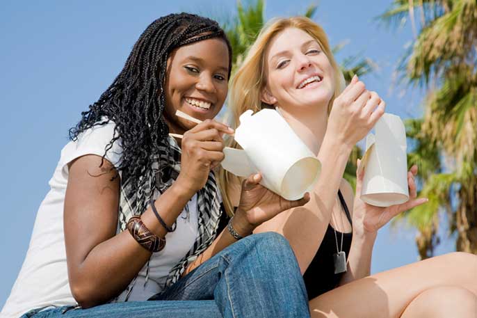 Young women eating Chinese takeout food (iStock)