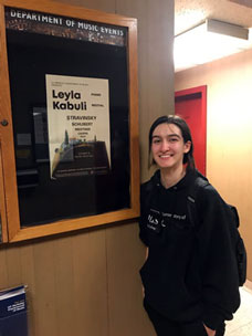 Leyla Kabuli in front of a poster advertising one of her performances