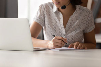 Woman with headset using laptop