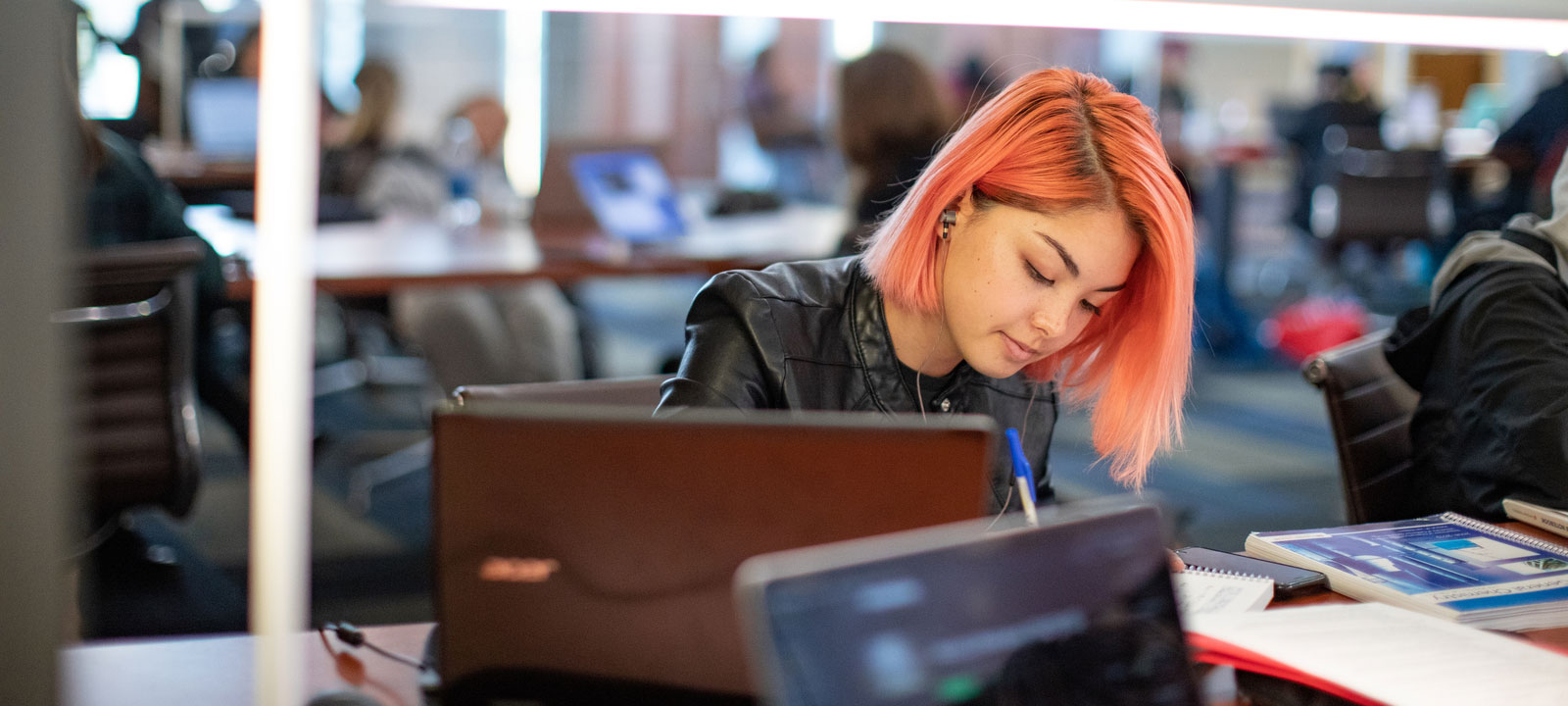 Young woman with orange hair studying