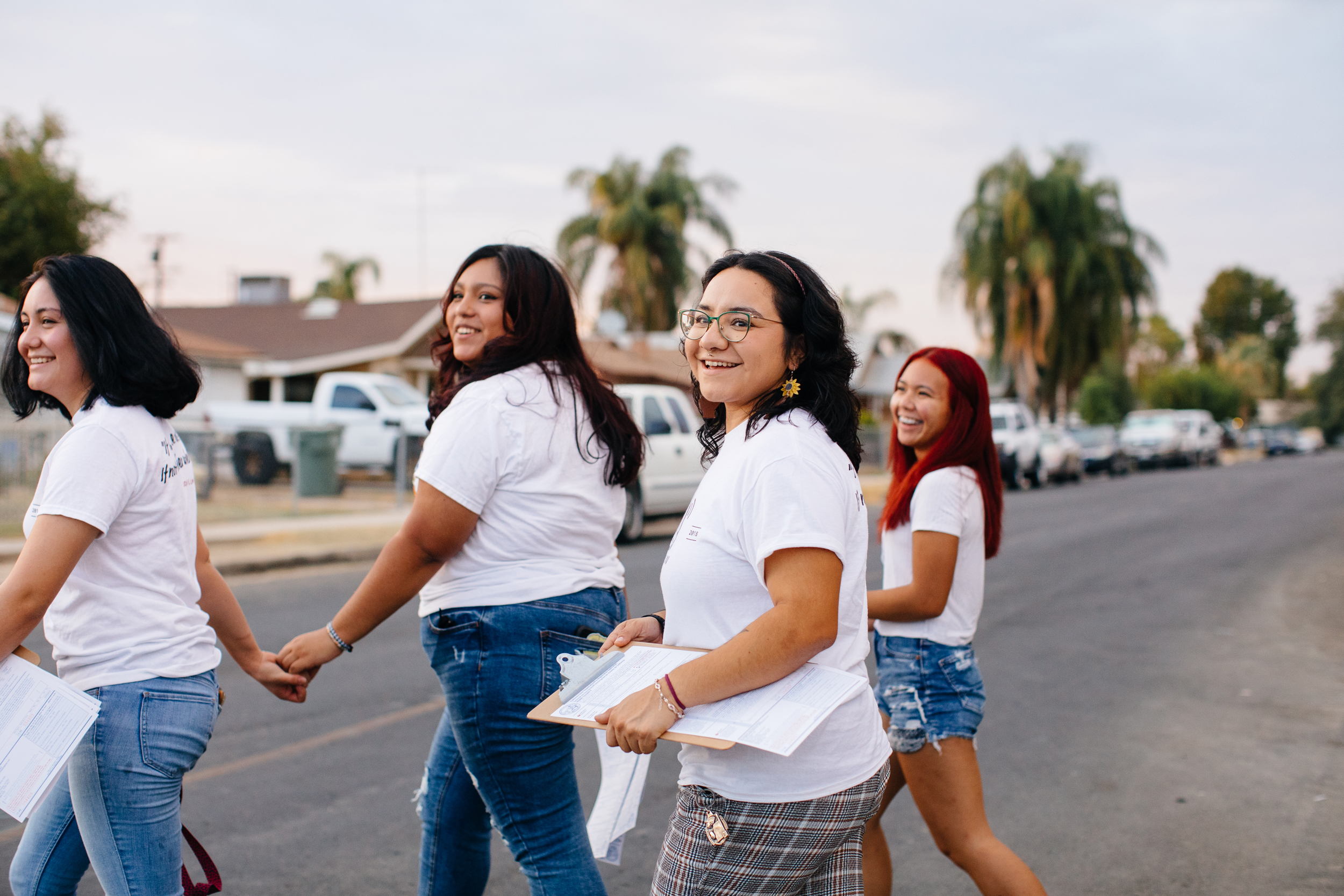 Four young women walking around a neighborhood in Delano doing voter registration