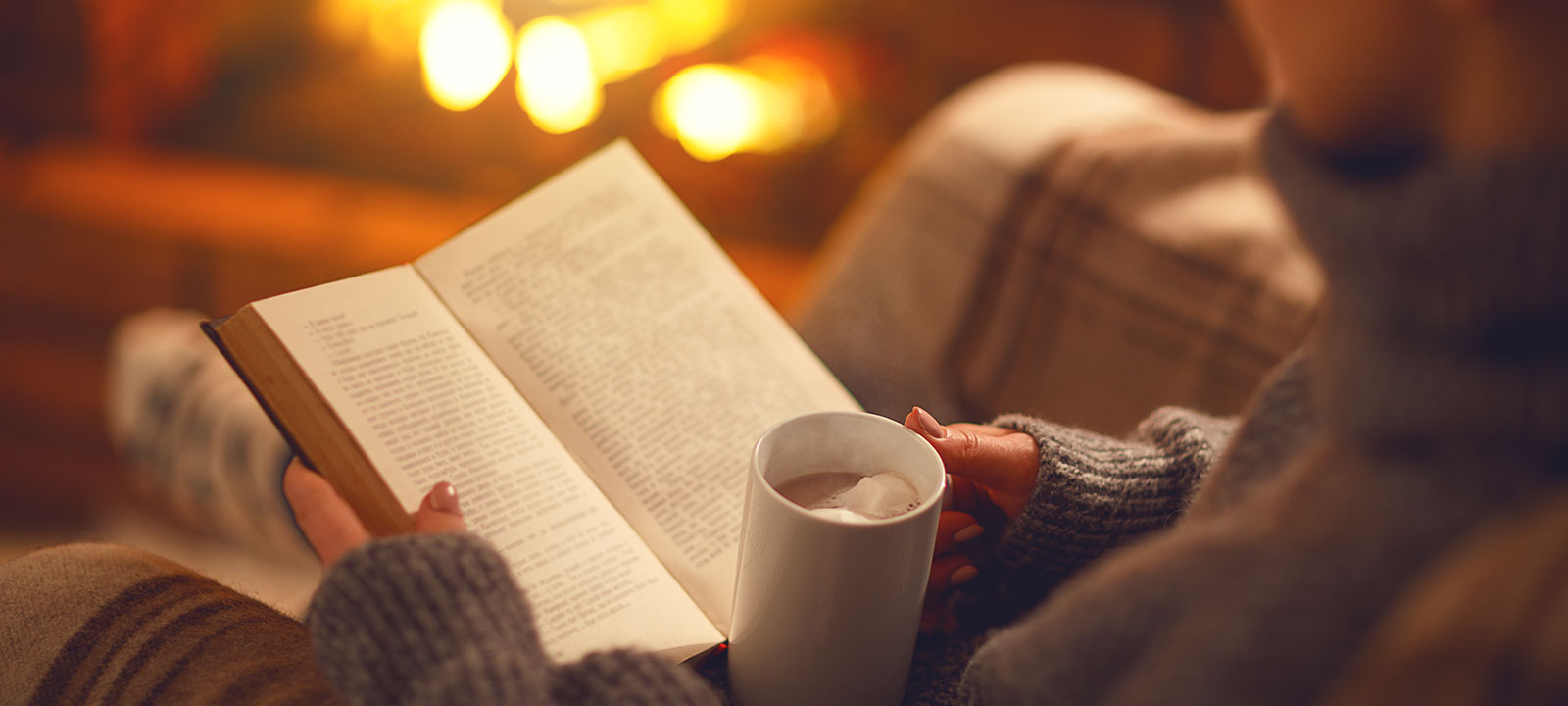 Woman reading book with cocoa