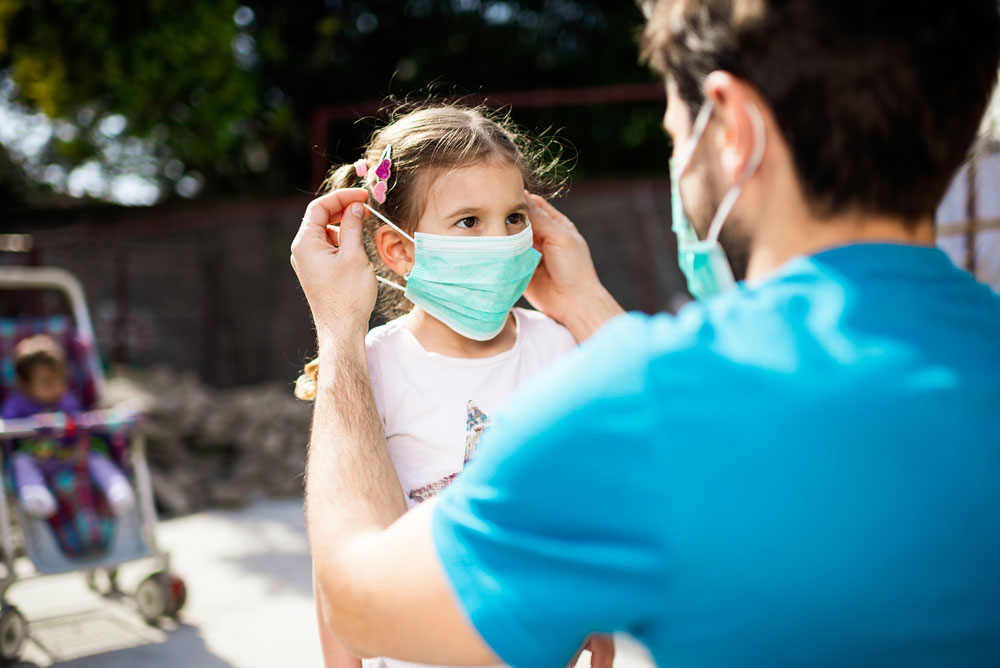 Man puts mask on child