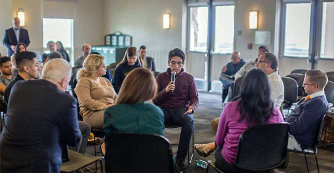 Jose Lopez in the center of a discussion circle