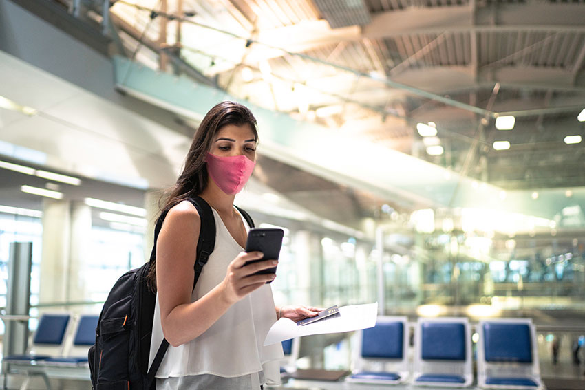 Woman at airport, checking her cell phone