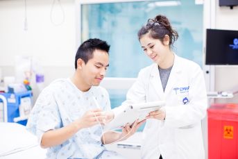 UCH medical professional working with a patient using an electronic tablet at a UCH hospital. Credit: University of California