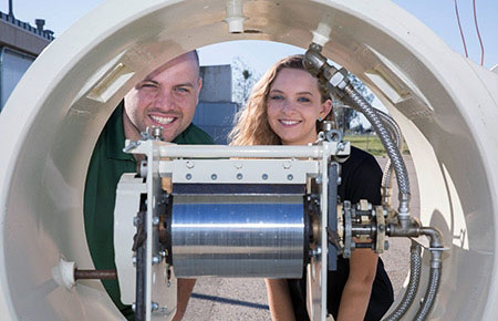 An undergrad and another student at a solar device