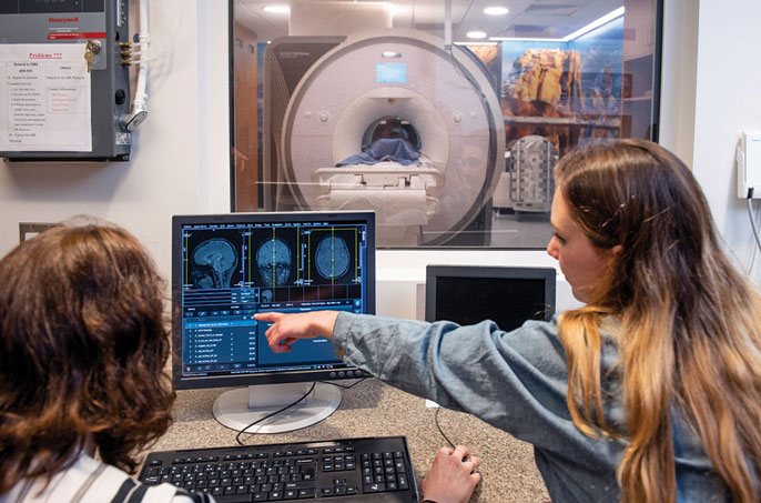 Doctor monitoring teen on an exercise machine