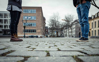 Two people standing socially distanced, only legs visible