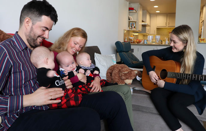 Music therapist plays for parents and their three triplets