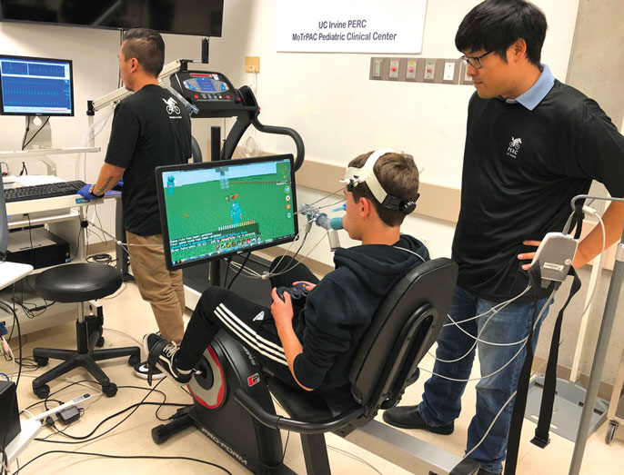 Kid exercising and playing video game in the lab