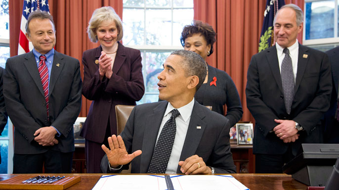 Peter Stock stands over President Obama as he signs a bill