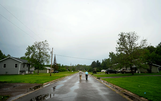 Pinter and Rees walk down the street in the rain