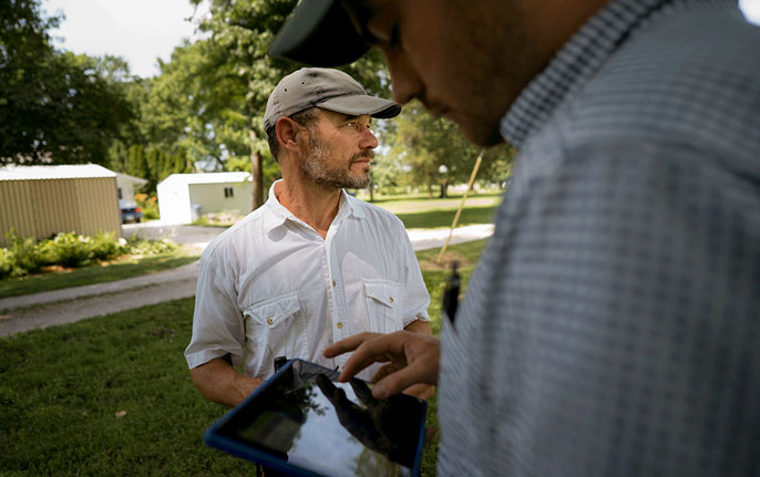 Nicholas Pinter and James Rees work together outside on an iPad