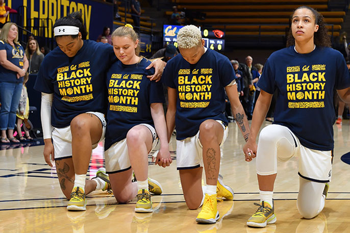 Women's college basketball players kneeling